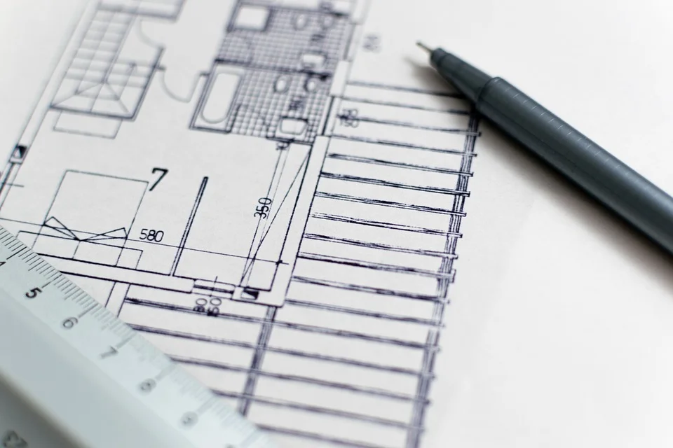 Plan d'architecture technique dessiné avec cotations, règle graduée et stylo noir sur papier blanc